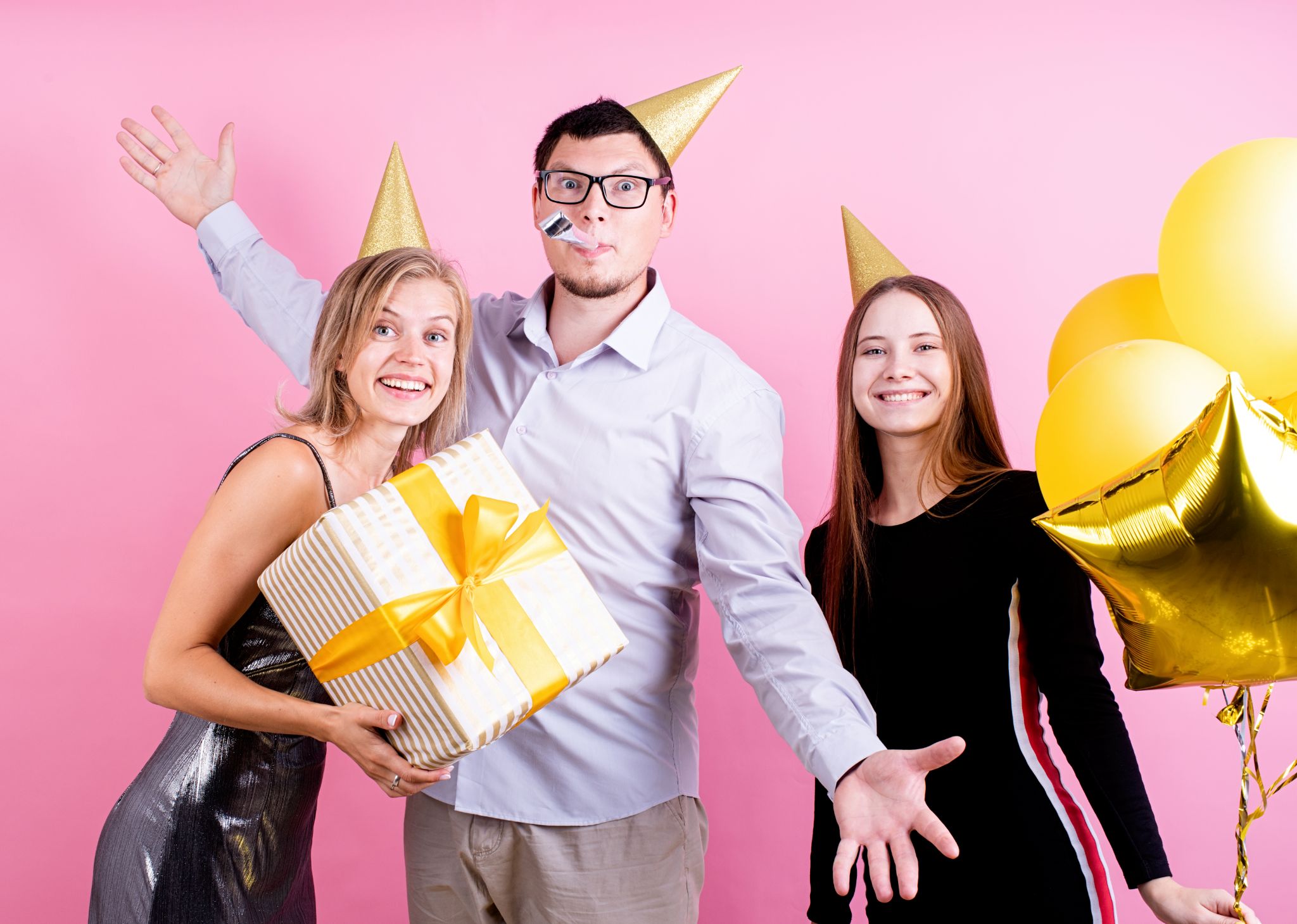 Portrait of joyful friends celebrating birthday party, pink background